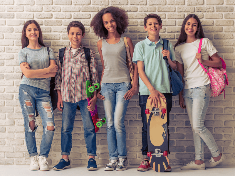 Teenage schoolgirls with backpacks walking together